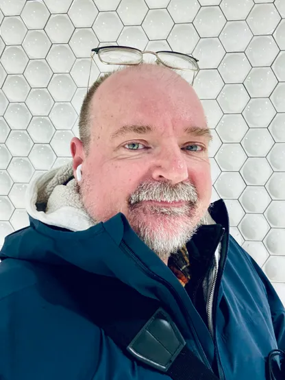 A selfie of me in front of a wall covered in white hexagons