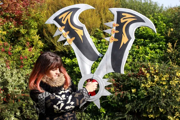 Vieille photo de moi quand j'avais les cheveux long, je tiens 2 épées de jeux vidéo dans les mains que j'ai réalisé (celles de Draven de league of legends)