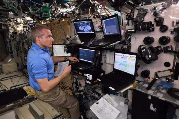 Astronaut David Saint-Jacques monitors Crew Dragon Demo 1's approach from the US Lab inside the International Space Station, March 2019.  RPOP is running on the center laptop, a display of mostly green on black, nearest his extended left index finger.