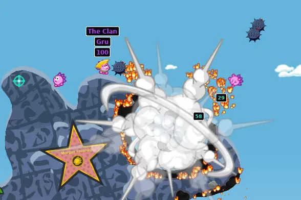 Screenshot of Hedgewars, a 2D game. A few pink comic hedgehog stand on a blue 2D terrain. One hedgehog is facing left, another hedgehog wears a hat and is facing left and stands right to an air mine. In the middle, a large fiery explosion throws a hedgehog away to the right. One of the hogs is labelled "The Clan | Gru | 100". Damage indicators with numbers 29 and 58 are shown close to the exploding hedgehog.