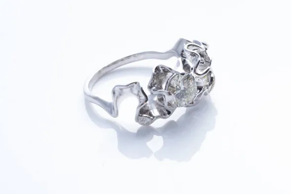 Florescence engagement ring in white gold with sparkling gemstones embedded among ruffles of metal