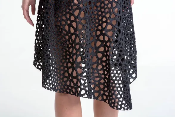 Close up of 3D-printed dress showing how it’s made of triangular hinged parts. Dress is black