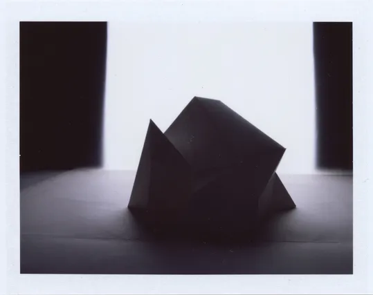 Polaroid photograph of a paper model of an iceberg