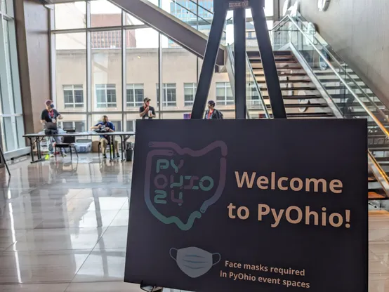 Welcome to PyOhio Sign with registration desk and staff in the background