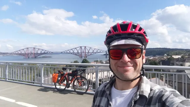 Me with my bike in touring setup on the Forth bridge in Scotland.