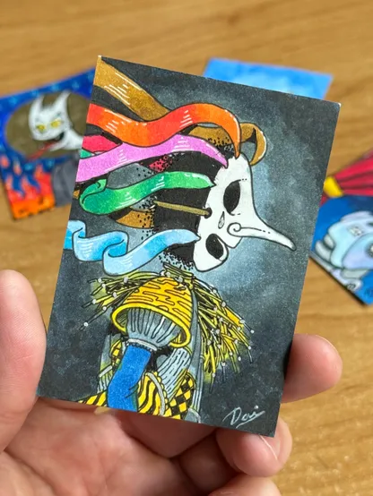 An illustrated card featuring a smoke like black featureless character with a mask, colorful ribbons flowing from it, and a detailed outfit with yellow and black patterns. The background is dark, and other colorful cards are visible in the background.