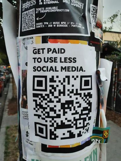 Poster on a telephone pole that says "get paid to use social media" above a QR code