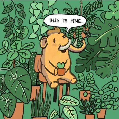 O mascote do Mastodon (um mastodonte) sentando em uma cadeira, rodeado de plantinhas, falando "This is fine".