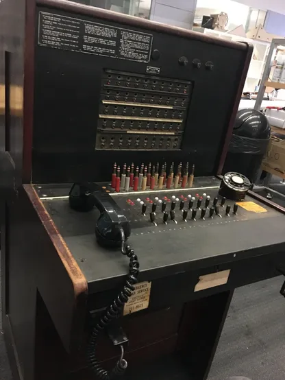 A photo of a telephone switchboard about the size of a desk