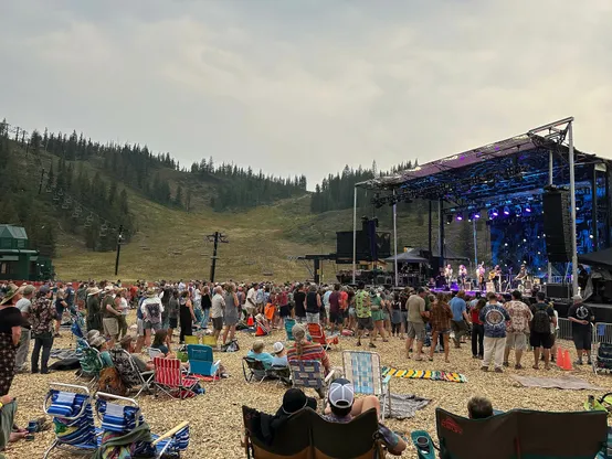 Crowd of people beginning to gather around the live music from Greensky Bluegrass. Fundraising concert hosted at a ski area, Hoodoo in Central Oregon. 