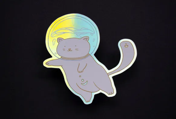 A holographic sticker of a chonky astronaut cat.