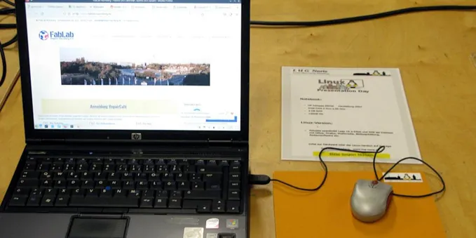 Linux Presentation Day: 
Ein altes Notebook mit aktueller Linux-Version auf einem Tisch mit Beschreibung und Maus zum Ausprobieren. 