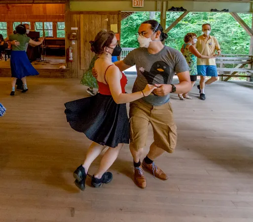 Me dancing with a partner in a wooden outdoor pavillion.