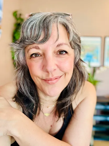 This is a selfie style photo of Shannon leaning on a table in a coffee shop 