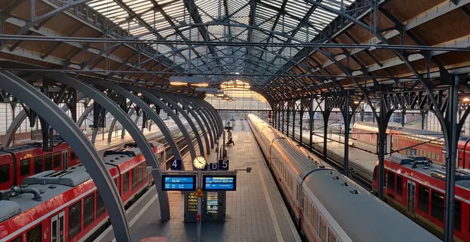 Picture of a sunset inside the Lübeck Central Station in Germany. The sunshiwn is glowing golden through the glass fassade