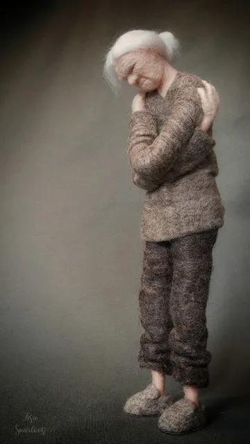 A needle felted woman hugging herself with closed eyes, remembering someone who is dearly missed