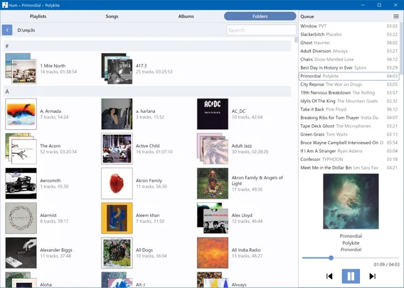 A screenshot of a Windows program showing a grid view of album art, a bunch of songs in the queue, and the currently playing track
