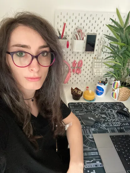 selfie in front of my current desk with some computer toolks, a plant and my laptop