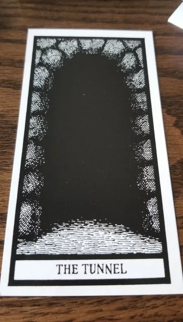 Grayscale tarot card depicting a stone arch entry to a pitch black tunnel. The Tunnel printed at the bottom in a gothic font.