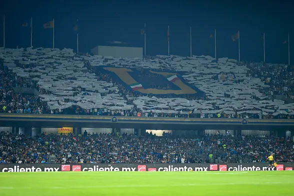 photo from the field at Estadio Olimpico Universitario before a match of midfield on the foreground and the fans at the back