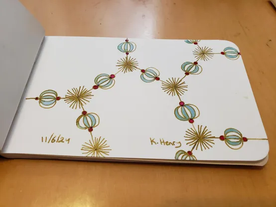 Hand drawn generative/procedural art in ink on an open page of my sketchbook. The abstract pattern looks a bit like a fancy organic chemistry diagram with beads.