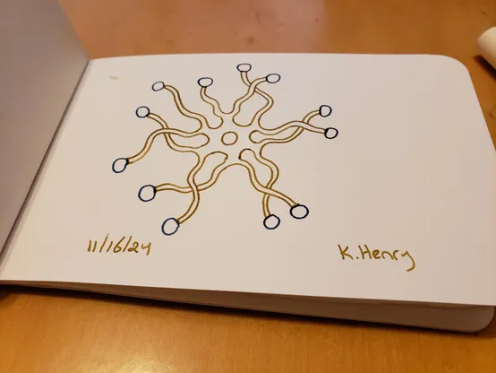 Hand drawn generative art in ink on an open page of my sketchbook. The abstract pattern looks a bit like an imaginary jellyfish.