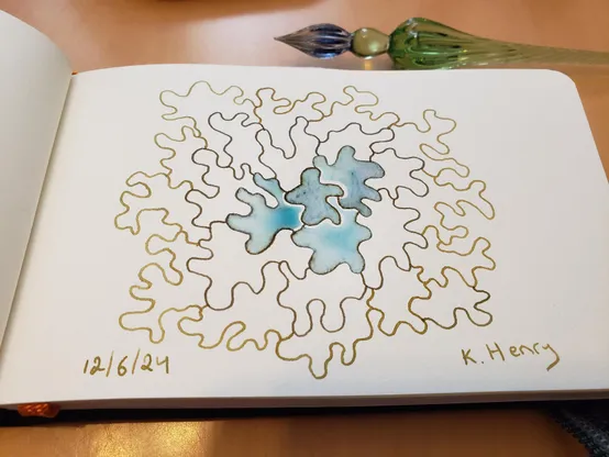 Hand drawn generative/procedural art in ink on an open page of my sketchbook. The abstract pattern is inspired by lichen. My glass dipping pen is next to my sketchbook.