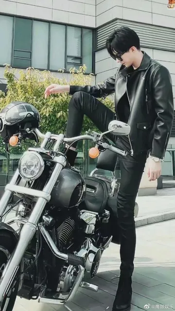 Yuning getting on a motorcycle, wearing all black and in duds. This picture is 75% legs. Yes. His legs.