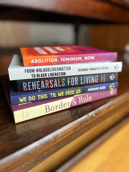 A pile of books, including Abolition. Feminism. Now., From #BlackLivesMatter to Black Liberation, Rehearsals for Living, We Do This ‘Til We Free Us, and Border & Rule