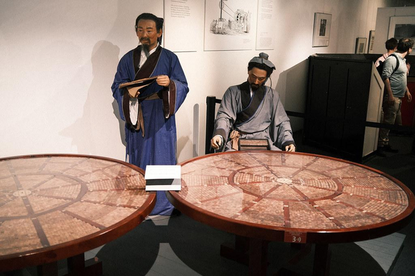 Round table with wooden stamp letters. Tables of this kind were used to sort the thousands of characters required for printing with movable type and played a crucial role in the efficiency and organization of the printing process. The round shape of the table allowed for easy rotation, enabling printers to quickly access different sections without moving around the workspace. The surface of the table was divided into multiple compartments or small boxes, each holding a specific set of characters. This segmentation helped in organizing the characters systematically.