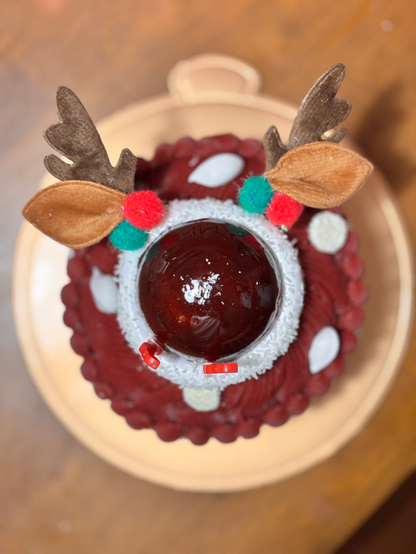 A Christmas cake shaped like the face of Rudolph the Red-Nosed Reindeer.