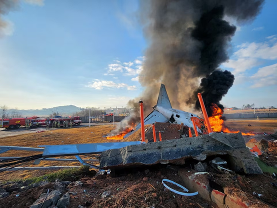 Firefighters carry out extinguishing operations on an aircraft which drove off runaway at Muan International Airport in Muan, South Jeolla Province, South Korea