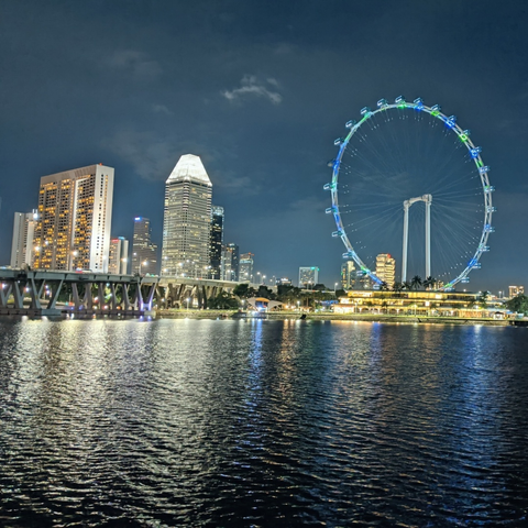 Waterfront view of buildings, ferris wheel and bridge captured with Google Pixel in Singapore