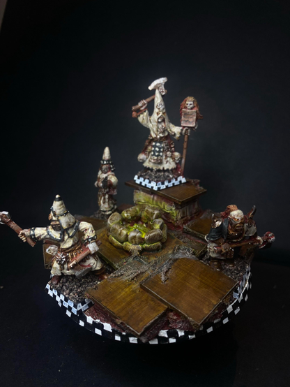 Four Cultists of the Possessed from the Mordheim range positioned on a scenic, glowing well base, they are dressed in dirty black and white robes covered in patterns. Again, another FediPaint entry.