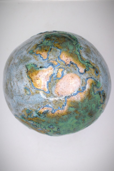 The top of a ceramic handmade globe, where you can see the northern continents and the North Pole.