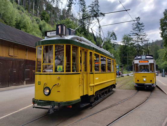 Zwei alte zweiachsige Straßenbahnen stehen nebeneinander