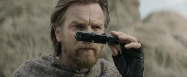 A picture of Obi-Wan Kenobi, played by Ewan McGregor, taking his eyes off a weird ass Star Wars binoculars thing