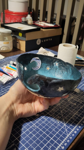 Yarn bowl made with air dry clay and painted with shades of blue. It's not yet finished.