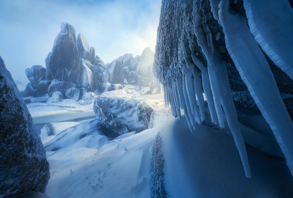 a cold rocky image of the Australian Alps with icicles on the right hand side & hash light hitting a pointy rock on the background