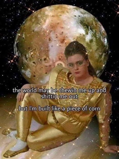 A meme of a lady that is laying on her side with text over the picture saying "the world may be chewin me up and shittin me out but I'm built like a piece of corn" 