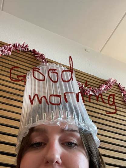 A picture of a woman with bubble wrap on her head and a handwritten good morning on the picture 