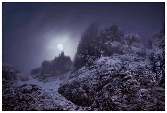 Moonset over Tasmanian dolerite spires, during the depth of a mid-winter night. Blanketed by snow and ice and enveloped in cloud.