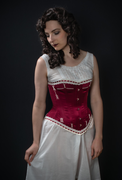 Photo de la corsetière vêtue de ses créations : une reproduction de corset et chemise en dentelles de la fin du 19ème siècle.