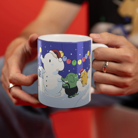 Photo of the Mastodon Winter Mug, showing multiple Mastodon mascots playing in the snow with one making a snowman.