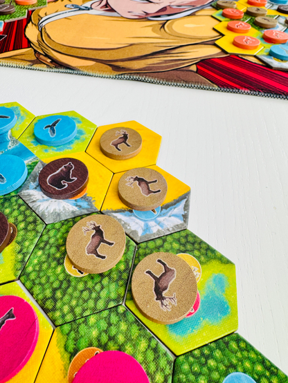 Cascadia boardgame on a white tabletop. Focus is on the tokens with printed Elk animal