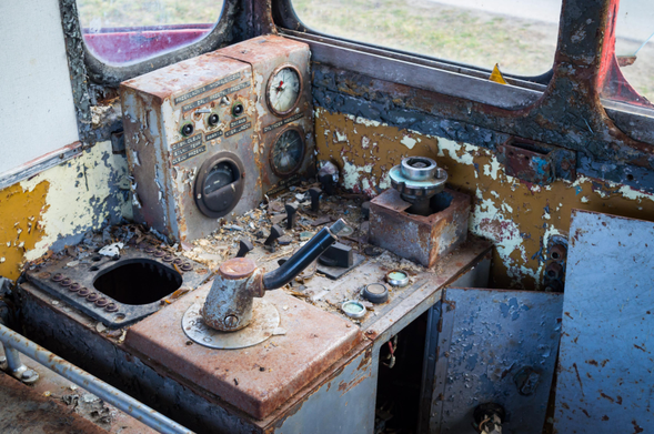 Inside of the driver's cabin of the Lxd2 locomotive. Paint has near completely flaked off, all metal elements are entirely rusted. 