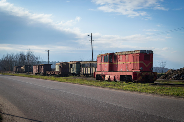 Shot on the vehicles from across the road, showing the locomotive and various coaches and platforms