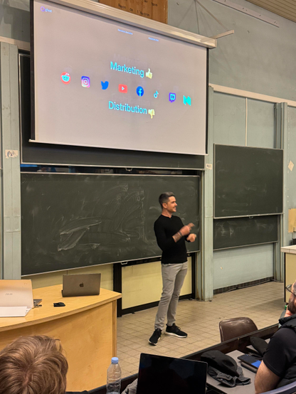 John O’Nolan from Ghost standing below a slide showing logos of Reddit, Instagram, Twitter, YouTube, Facebook, TikTok, Twitch and Medium.