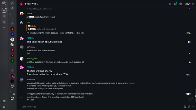 A screenshot of a dark-themed chat interface shows a conversation thread.  Multiple users, identified by profile icons and usernames like "Fabrix," "joern," "FOSDEM," and "bitPickup," are exchanging messages.  The messages discuss the end of a talk, a live channel URL, questions not being read, and a recording of the talk's screen.  One message mentions Friendica, a software, and its presence since 2010.  The overall context suggests a live online event or discussion.