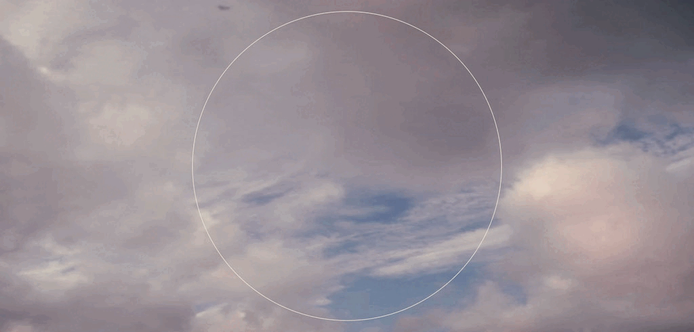 An animated gif of a yet-to-be-released artwork. A video feed of overhead clouds has a synthetic circular overlay, showing lines and arrows that move with the clouds.